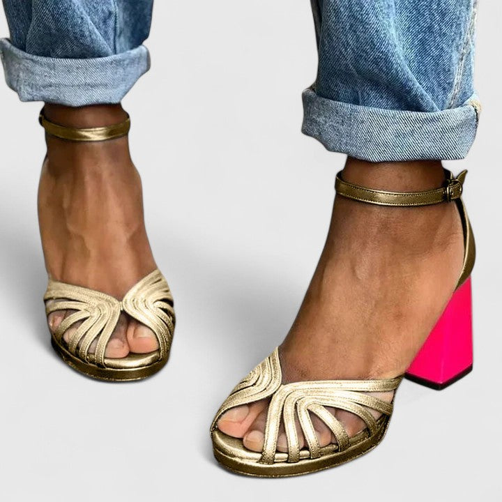 Gold Noelyrah Sandaal heels by THE WHITMORE FAMILY featuring elegant, sophisticated design with a sleek heel and stylish straps.