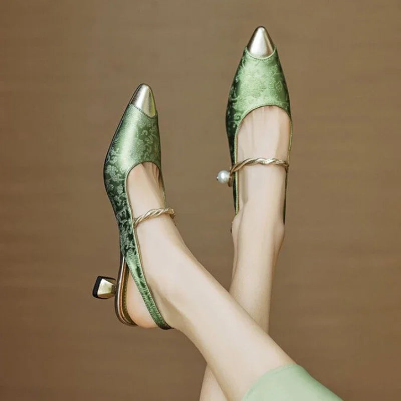 Green sandal featuring elegant pumps design by THE WHITMORE FAMILY, showcasing a refined and sophisticated style.