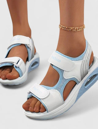 White and black Rhea™ Cushy Sandals by THE WHITMORE FAMILY featuring cushioned straps and a comfortable open-toe design.