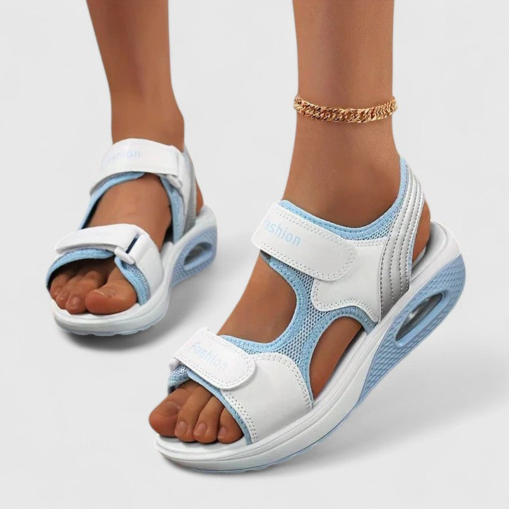 White and black Rhea™ Cushy Sandals by THE WHITMORE FAMILY featuring cushioned straps and a comfortable open-toe design.