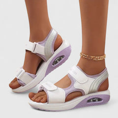 White and black Rhea Cushy Sandals by THE WHITMORE FAMILY featuring cushioned straps and a comfortable slip-on design.