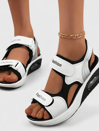 White and black Rhea Cushy Sandals by THE WHITMORE FAMILY featuring soft straps and cushioned soles for comfortable wear.