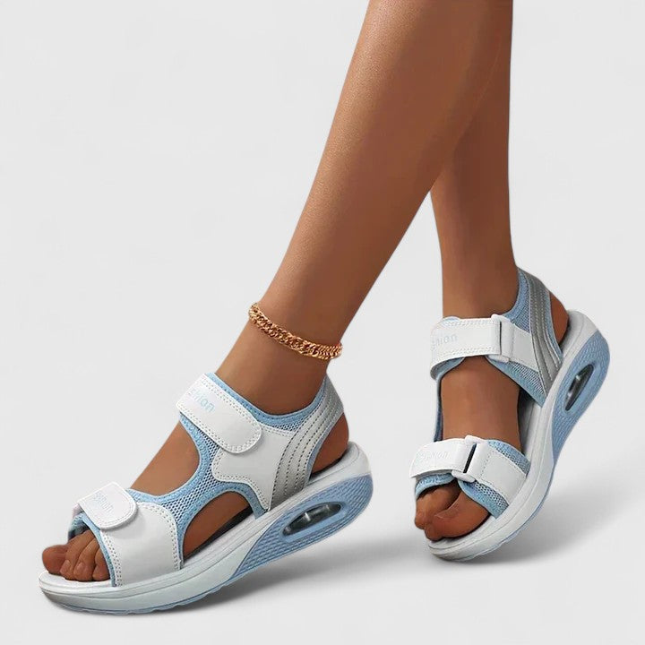 White and black Rhea™ Cushy Sandals from THE WHITMORE FAMILY with cushioned straps and a comfortable slip-on design.