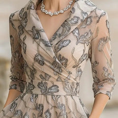 Marceline classic graceful short sleeve midi dress in apricot by THE WHITMORE FAMILY, displayed on a hanger.