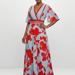 Corinne floral maxi dress with V-neck and short sleeves by THE WHITMORE FAMILY, shown in a colorful, flowing fabric.