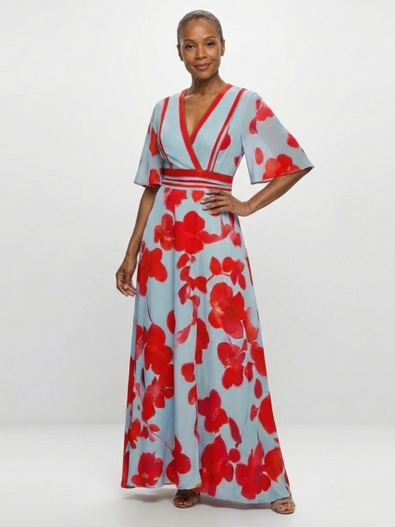 Corinne floral maxi dress with V-neck and short sleeves by THE WHITMORE FAMILY, shown in a colorful, flowing fabric.