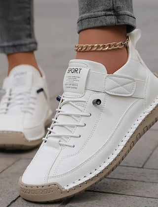 White Éva™ ergonomic support sneakers by THE WHITMORE FAMILY, showcasing comfortable, stylish sneaker design with cushioned soles.