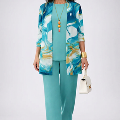 Refined three-piece trouser set by THE WHITMORE FAMILY featuring tailored tops and matching trousers, modeled in a stylish indoor setting.