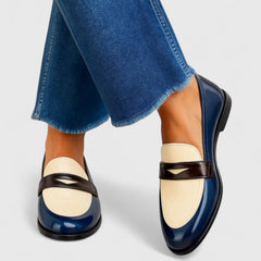 White Flixie elegant loafers by THE WHITMORE FAMILY, showing a close-up of classic slip-on shoes with sleek design.