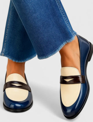 White Flixie elegant loafers by THE WHITMORE FAMILY, showing a close-up of classic slip-on shoes with sleek design.