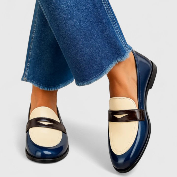 White Flixie elegant loafers by THE WHITMORE FAMILY, showing a close-up of classic slip-on shoes with sleek design.