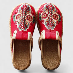 Handmade floral mules by THE WHITMORE FAMILY featuring comfortable, stylish design with white floral accents.