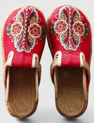 Handmade floral mules by THE WHITMORE FAMILY featuring comfortable, stylish design with white floral accents.