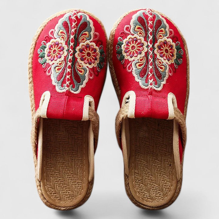 Handmade floral mules by THE WHITMORE FAMILY featuring comfortable, stylish design with white floral accents.
