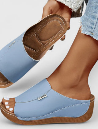 White Celestria™ orthopedic sandals by THE WHITMORE FAMILY with cushioned soles and supportive straps, designed for comfort.