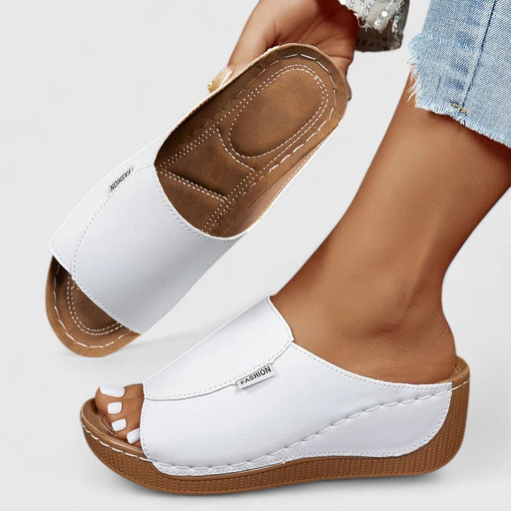 White Celestria™ orthopedic sandals by THE WHITMORE FAMILY with cushioned straps and supportive soles for comfort.