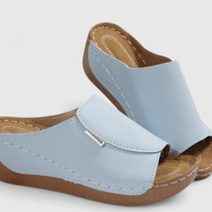 White Celestria™ orthopedic sandals by THE WHITMORE FAMILY with cushioned soles and supportive straps, designed for comfort and style.