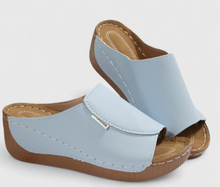 White Celestria™ orthopedic sandals by THE WHITMORE FAMILY with cushioned soles and supportive straps, designed for comfort and style.
