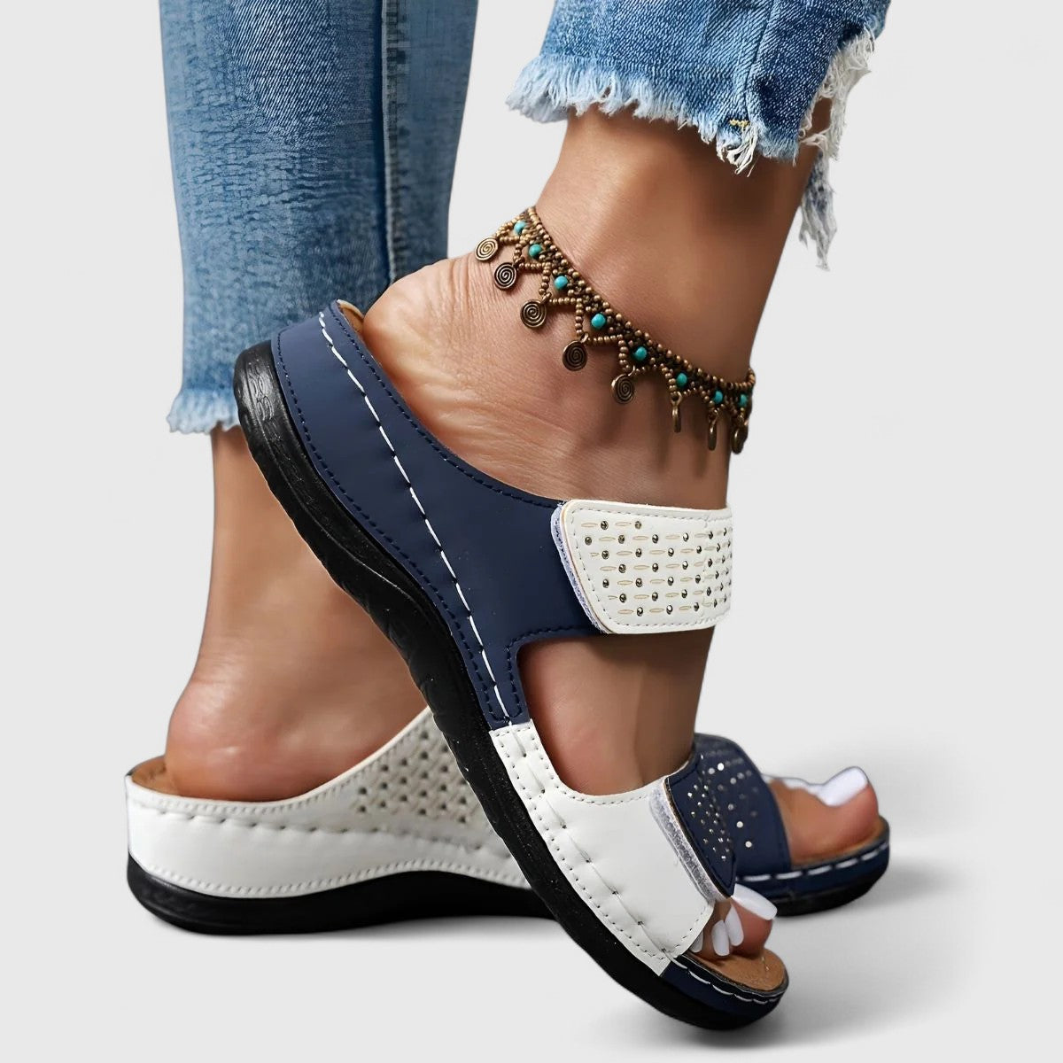 White Karyssa™ orthopedic sandals by THE WHITMORE FAMILY with cushioned soles and adjustable straps, designed for comfort.
