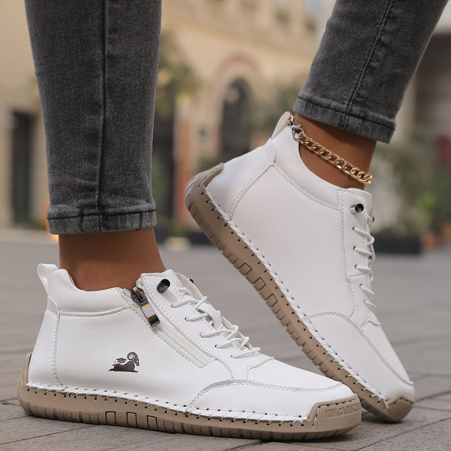 White Maïa™ ergonomic support sneakers by THE WHITMORE FAMILY, featuring cushioned soles and breathable design.
