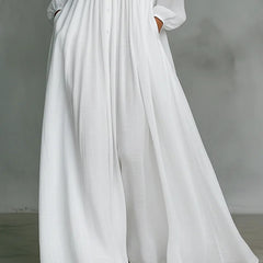 White Barbara flowing button-front maxi dress by THE WHITMORE FAMILY displayed on a model, featuring a relaxed fit and elegant design.