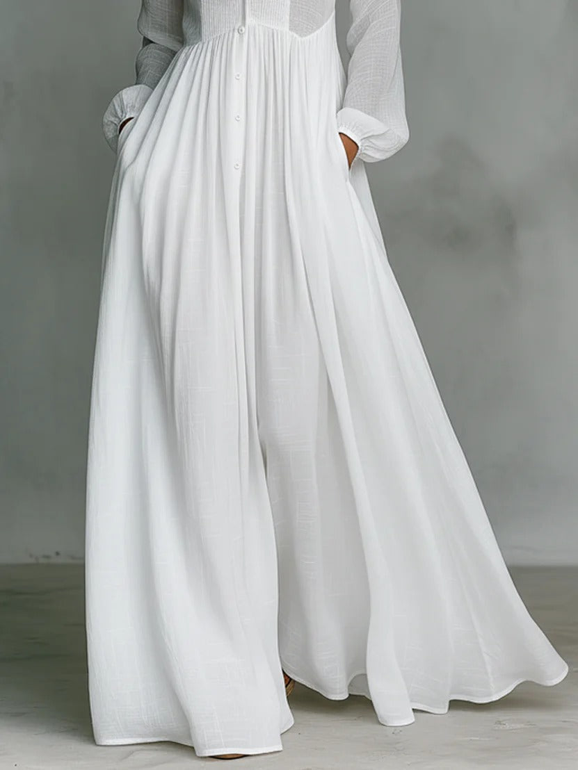 White Barbara flowing button-front maxi dress by THE WHITMORE FAMILY displayed on a model, featuring a relaxed fit and elegant design.