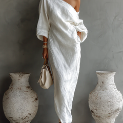 White Nelle™ Elegant Maxi Dress from THE WHITMORE FAMILY, flowing fabric, V-neckline, and sleeveless design on a model.
