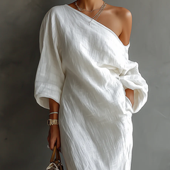 White Nelle™ Elegant Maxi Dress by THE WHITMORE FAMILY, featuring flowing fabric and a sophisticated design, shown on a model.