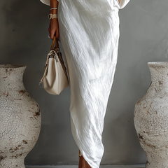 White Nelle™ Elegant Maxi Dress by THE WHITMORE FAMILY, flowing fabric and stylish design, shown in a close-up shot.