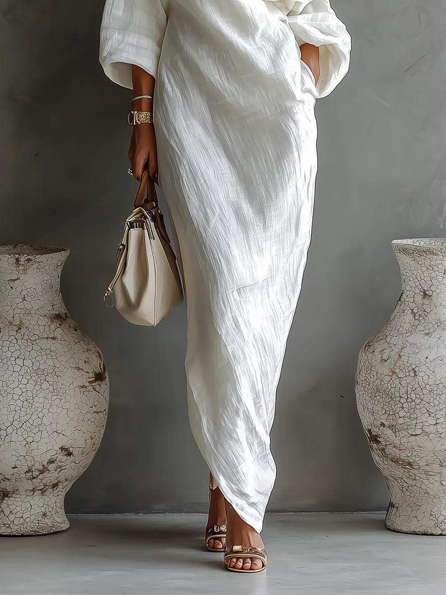 White Nelle™ Elegant Maxi Dress by THE WHITMORE FAMILY, flowing fabric and stylish design, shown in a close-up shot.