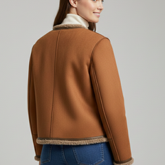 Women’s brown jacket by THE WHITMORE FAMILY with button closure and trim edging, featuring a stylish and fitted design.