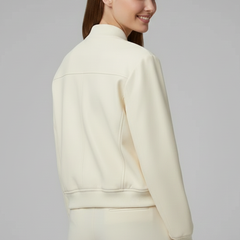 Beige women’s bomber jacket with baseball collar and snap buttons, by THE WHITMORE FAMILY, shown on a model.