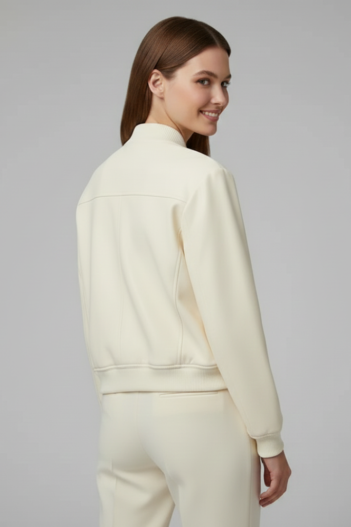 Beige women’s bomber jacket with baseball collar and snap buttons, by THE WHITMORE FAMILY, shown on a model.