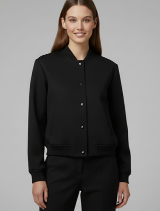 Beige women’s bomber jacket from THE WHITMORE FAMILY featuring a baseball collar and snap buttons, styled for casual wear.