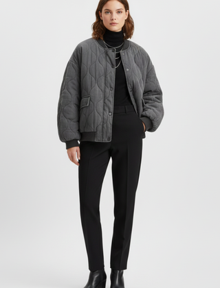 Women's grey bomber jacket by THE WHITMORE FAMILY with snap closure and quilted surface, styled for a casual look.