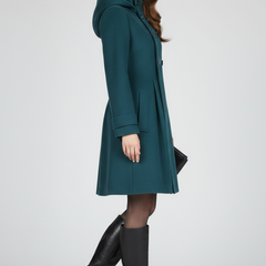 Black women’s coat with hood and double button front by THE WHITMORE FAMILY, shown on a female model.
