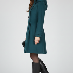 Black women’s coat with hood and double button front by THE WHITMORE FAMILY, shown on a model.