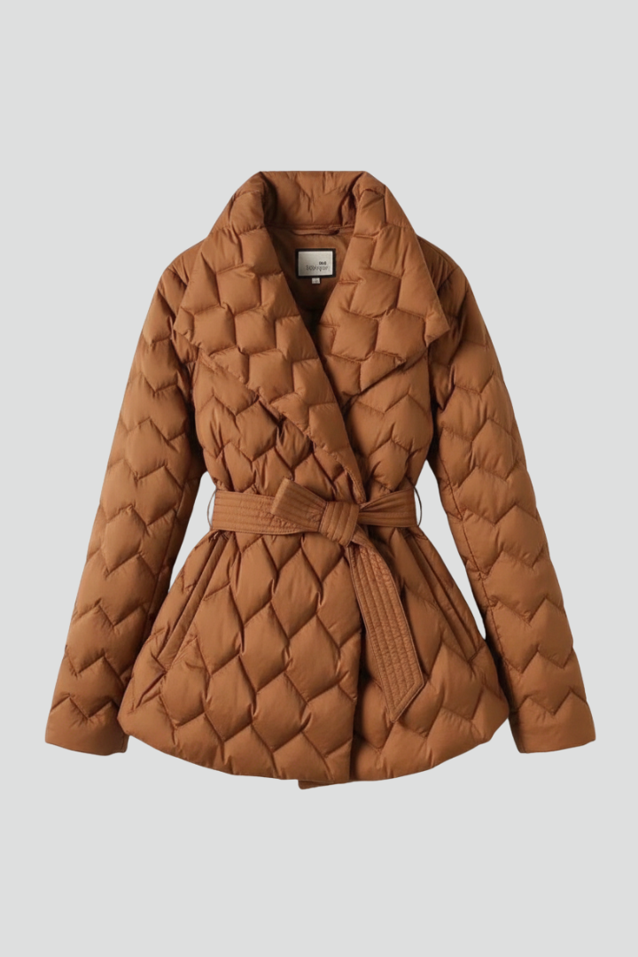 Women’s down coat by THE WHITMORE FAMILY in caramel with belted waist and deep pockets, shown on a model.