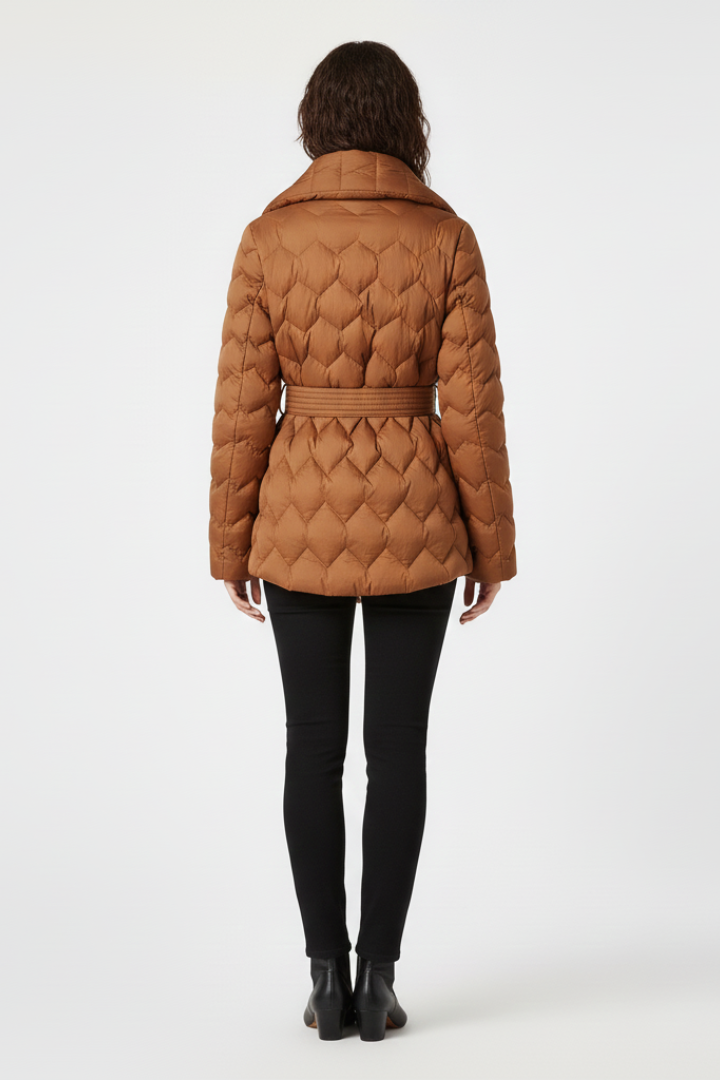 Women’s caramel down coat by THE WHITMORE FAMILY with belted waist and deep pockets, shown on a model.