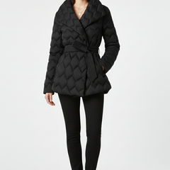 Women's down coat by THE WHITMORE FAMILY in caramel with a belted waist and deep pockets, shown on a model.