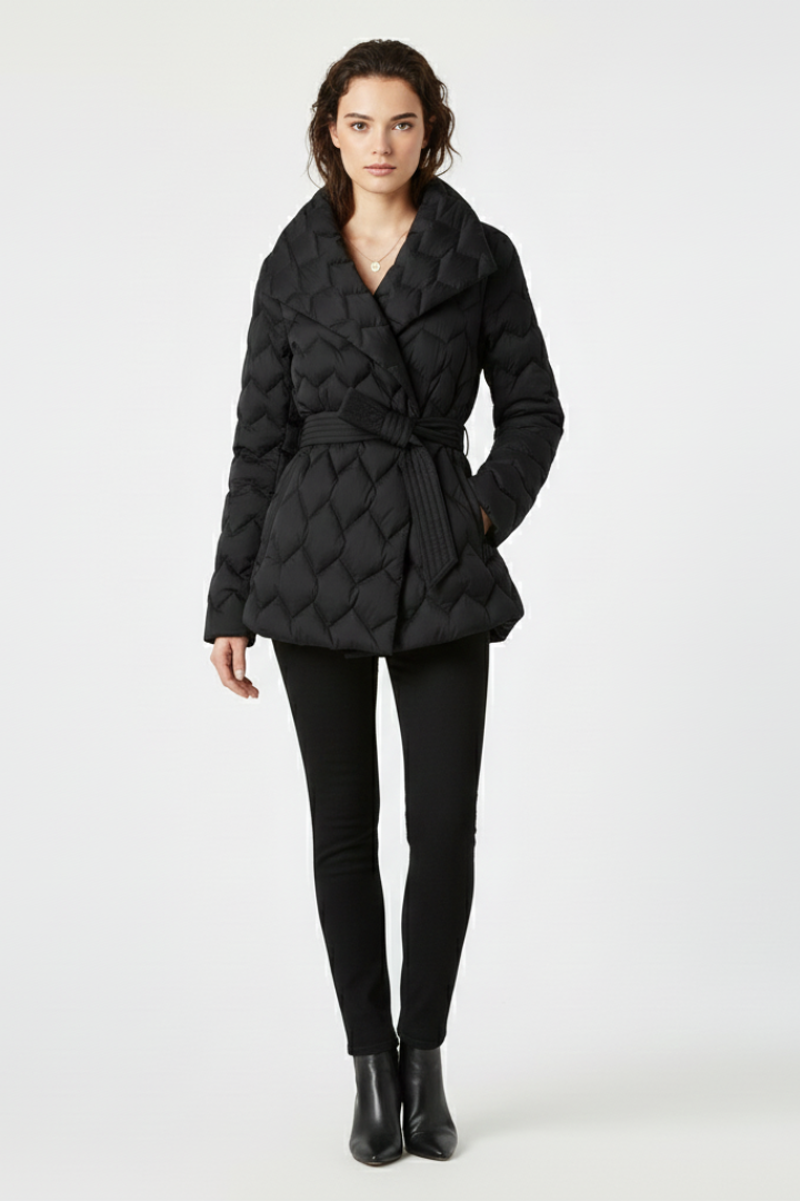 Women's down coat by THE WHITMORE FAMILY in caramel with a belted waist and deep pockets, shown on a model.