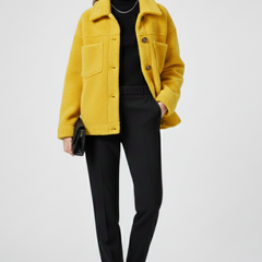 Women’s black fleece jacket by THE WHITMORE FAMILY featuring button closures and spacious pockets, shown on a model.