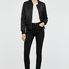 Women’s black bomber jacket by THE WHITMORE FAMILY with zipper closure and ribbed accents, displayed on a model.