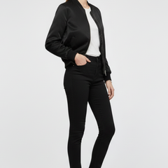 Black women’s bomber jacket by THE WHITMORE FAMILY with zipper closure and ribbed details, shown on a model.
