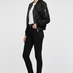 Women's black bomber jacket by THE WHITMORE FAMILY featuring zipper closure and ribbed details, shown on a model.