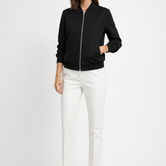Women's black bomber jacket by THE WHITMORE FAMILY with zip closure and ribbed edges, shown on a model.