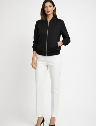 Women's black bomber jacket by THE WHITMORE FAMILY with zip closure and ribbed edges, shown on a model.
