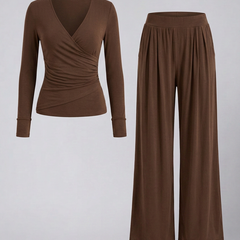 Women's lounge set featuring a wrap top and wide-leg pants by THE WHITMORE FAMILY, shown on a model in a cozy indoor setting.