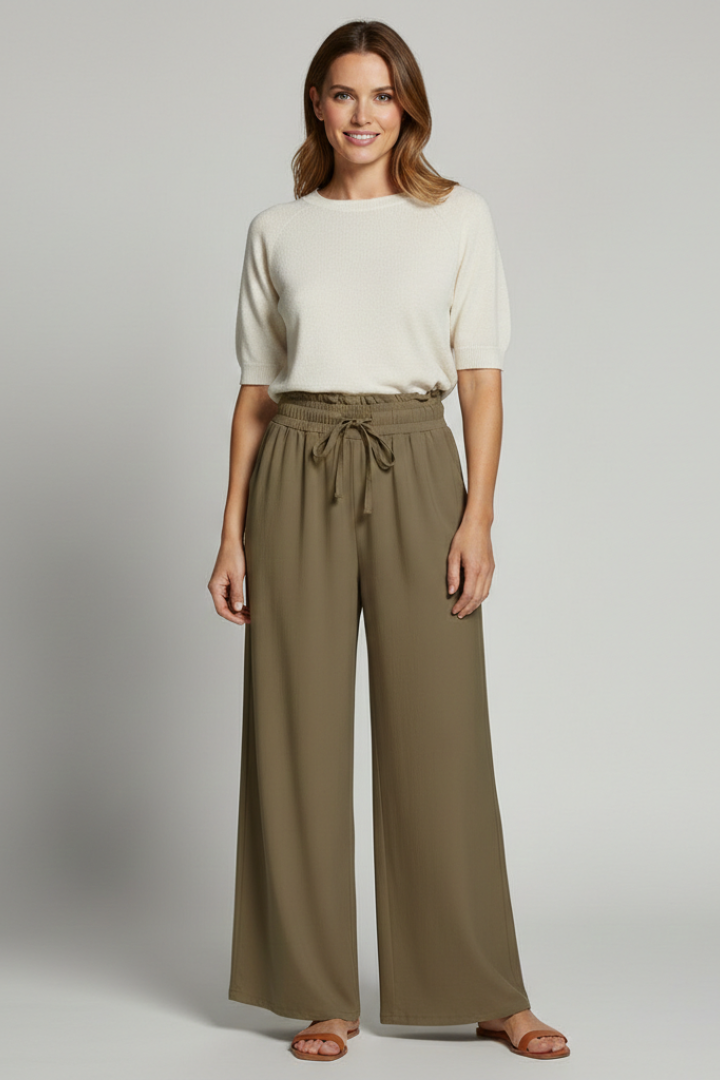 Women’s Palazzo Trousers by THE WHITMORE FAMILY featuring an elastic waist and side pockets, shown in a relaxed, flowy fit.