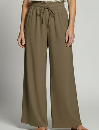 Women's palazzo trousers by THE WHITMORE FAMILY with elastic waist and side pockets, flowy and comfortable for casual wear.